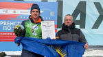биатлонист во время награждения с тренером